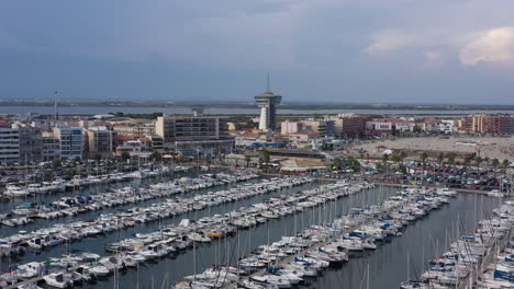 Aerial-flight-over-boats-in-Palavas-les-Flots-port-panoramic-restaurant-tower